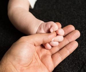 Baby holding dad hands