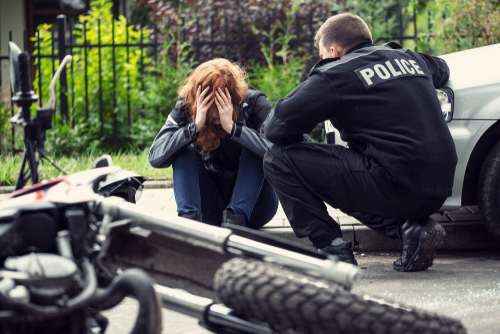 Policía ayudando a motociclista lesionado después de un accidente de motocicleta en la calle