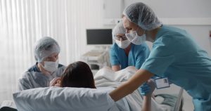 Equipo médico asistiendo a una paciente durante el parto