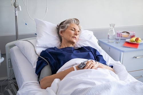 Elderly nursing home resident resting in hospital bed