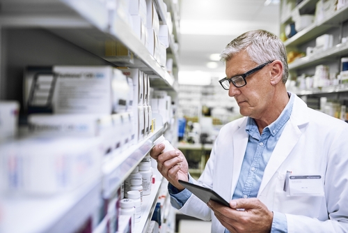 Farmacéutico revisando la etiqueta de un medicamento en una farmacia