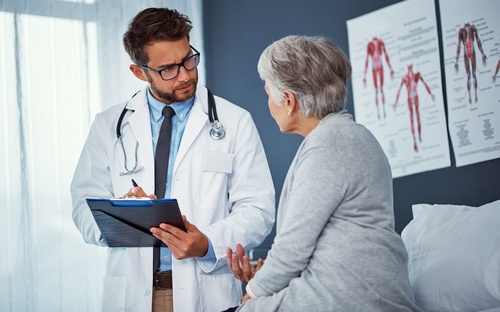 Médico hablando con paciente sobre cuidado posoperatorio