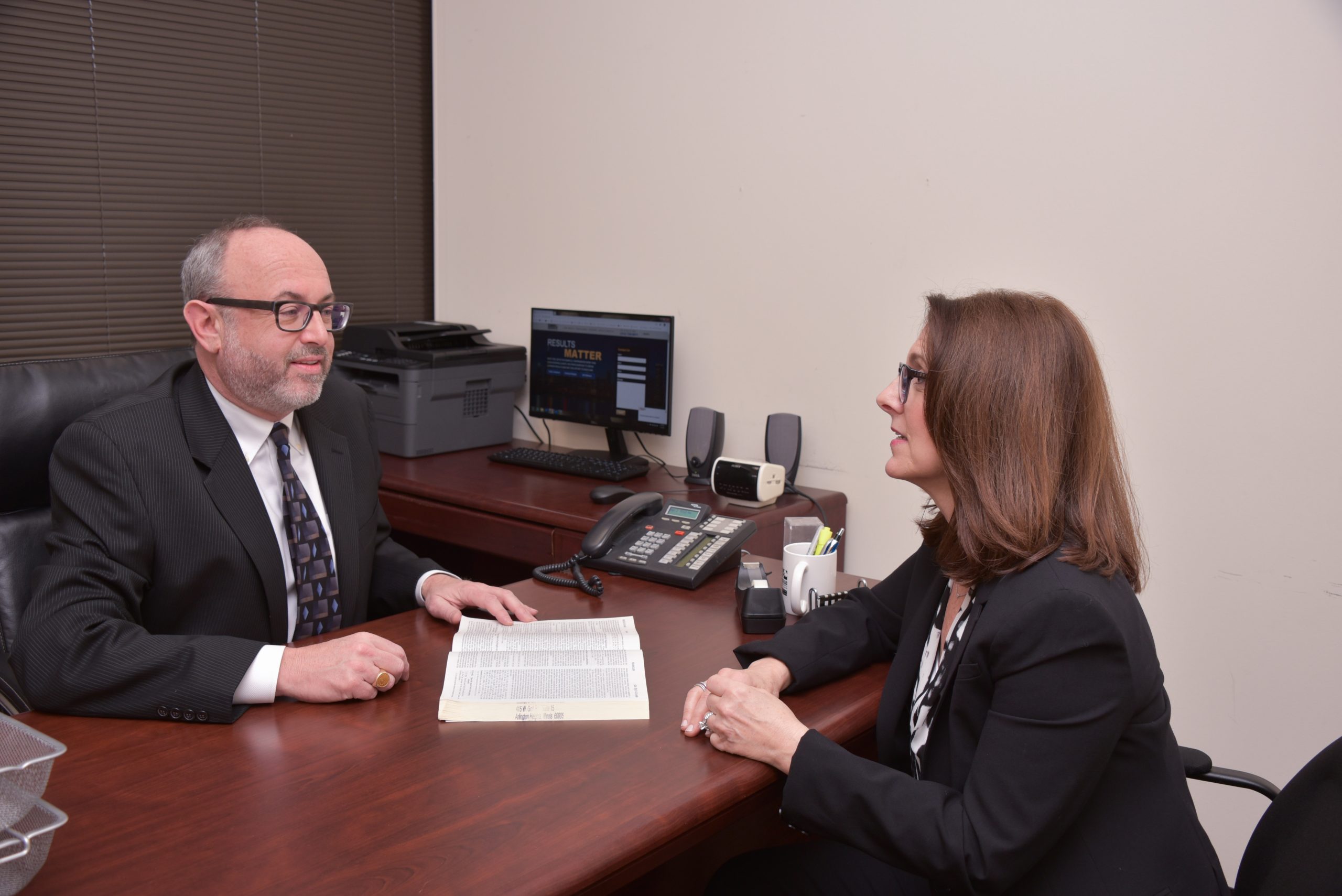 Two legal professionals discussing a case at an office desk