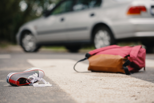 Zapato y mochila de niño en cruce peatonal después de un accidente