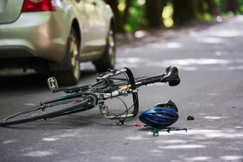 Bicycle, helmet, and debris on the road after a collision with a vehicle
