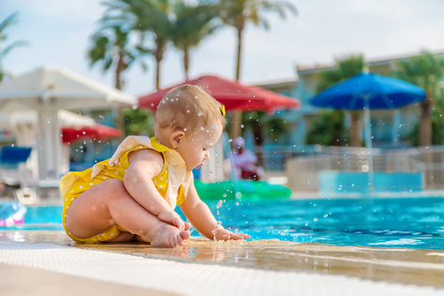 Baby sitting at the edge of a swimming pool showing drowning risk