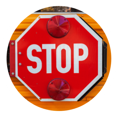 Red STOP sign mounted on the side of a yellow school bus